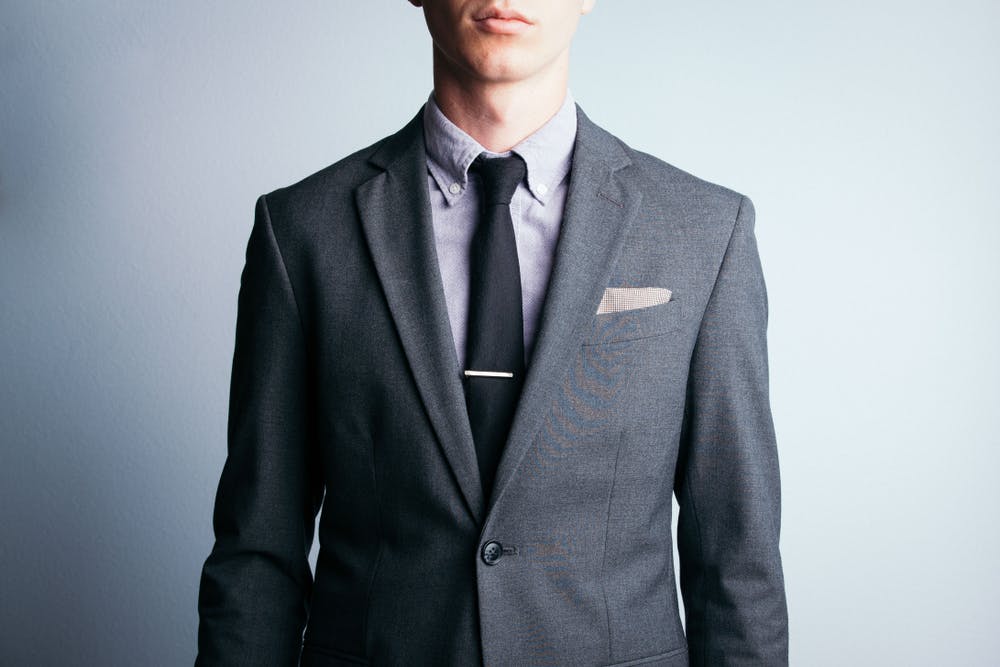 Homme portant un costume gris avec une cravate pour un entretien d'embauche