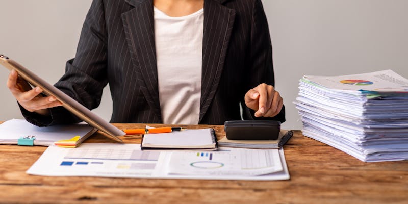 Femme travaillant sur le bureau avec l'aide de la calculatrice
