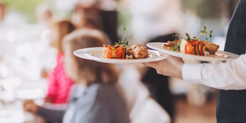 Une personne tenant des plats dans un restaurant.