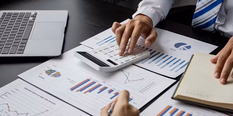Un homme qui utilise sa calculatrice sur des graphiques.