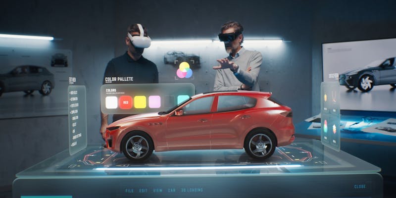 Deux hommes devant un robot permettant de changer la couleur d'une voiture.