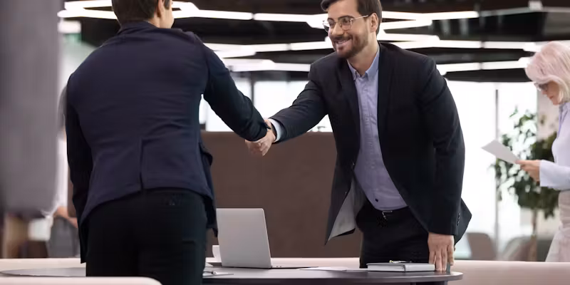 Deux hommes en costume se serrent la main.