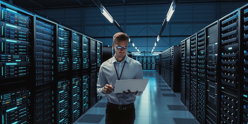 Un homme avec un ordinateur dans une salle informatique